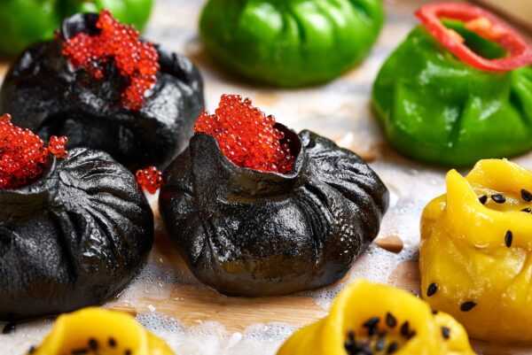 Momo (Tibetan dumplings) with salmon and spinach in truffle and cheese sauce